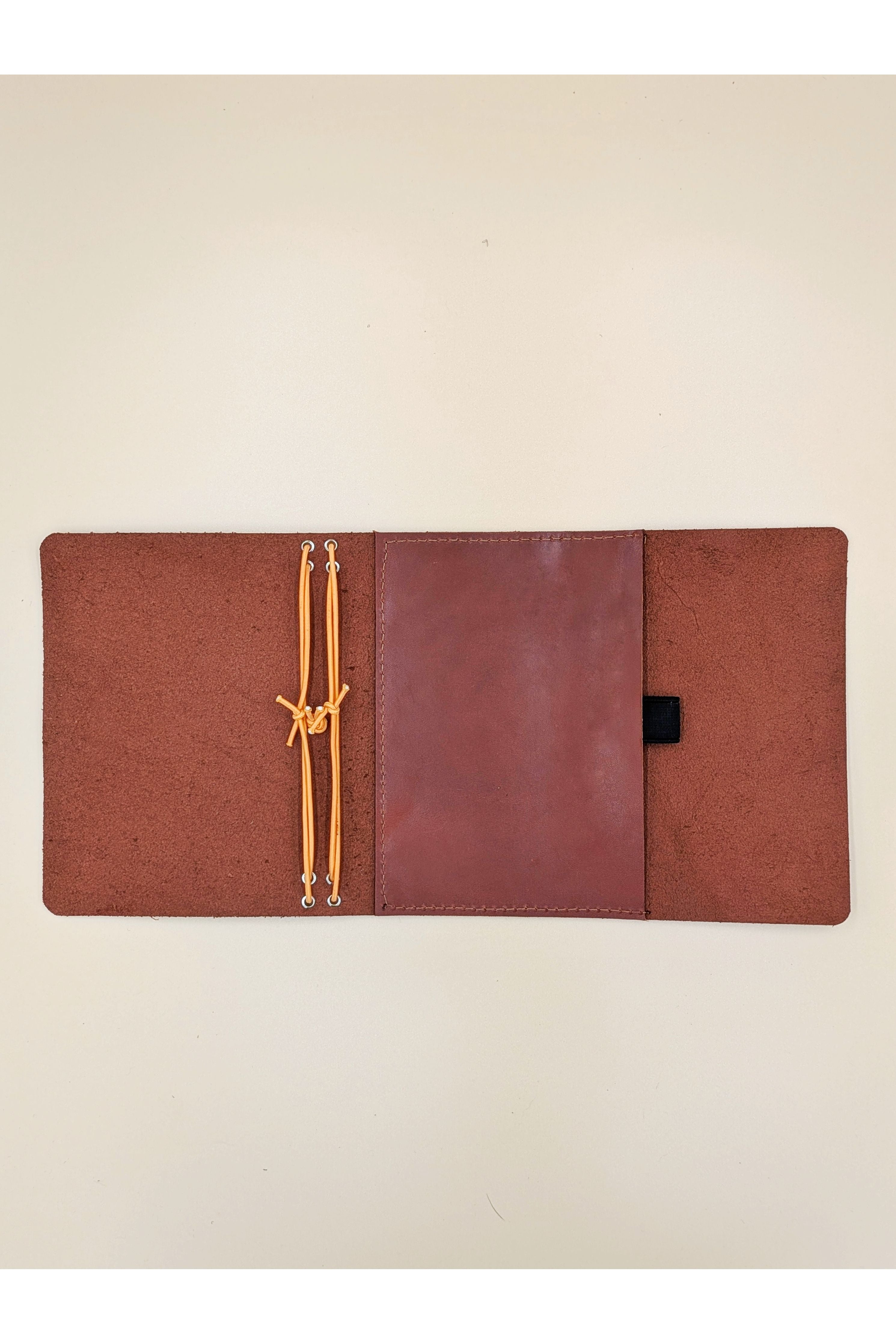 A6 tri-fold leather journal cover detail inside view with pocket and pen loop in Cognac Colour