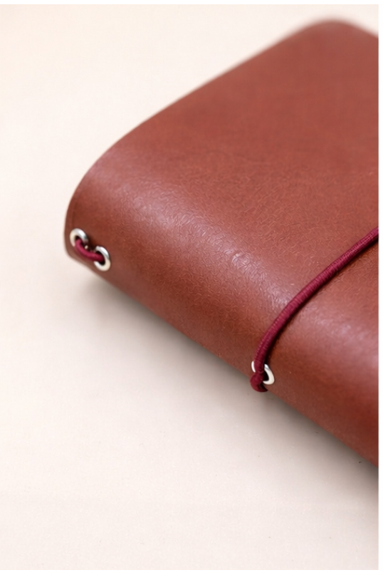 Passport size (B7) leather tri-fold journal cover in colour Cognac spine view side on
