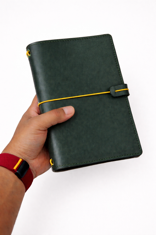 Leather bi-fold journal covers in forest green colour held in hand