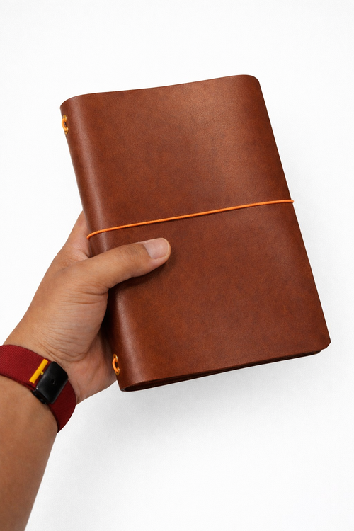 Leather tri-fold journal cover in Cognac colour held in hand