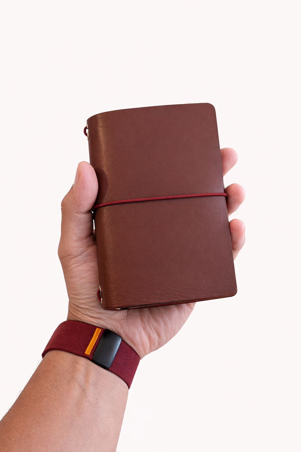 Passport size (B7) leather tri-fold journal cover in colour Cognac held in hand
